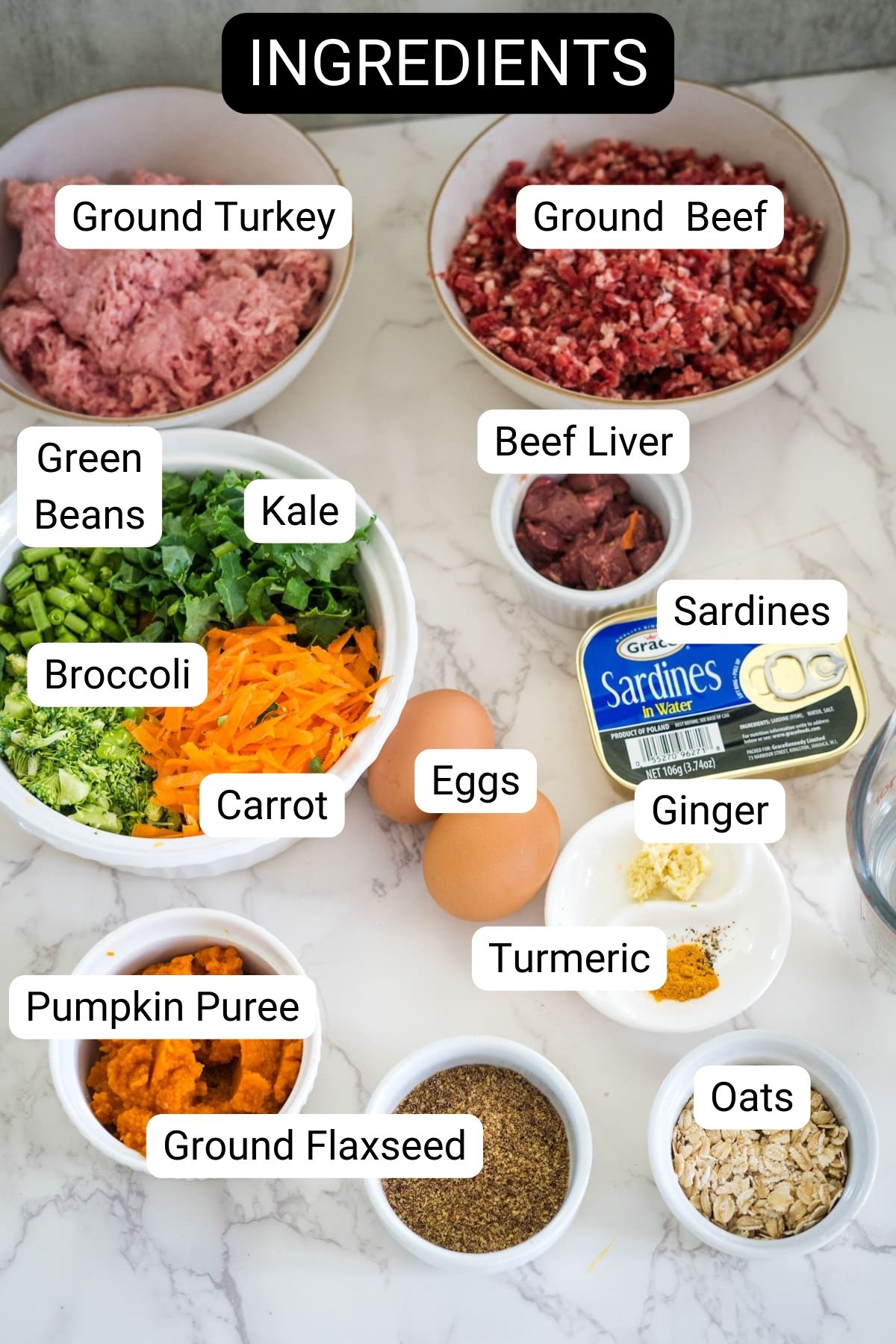 A variety of food ingredients are labeled, perfect for a turkey dog food recipe; these include ground turkey, ground beef, beef liver, sardines, green beans, kale, broccoli, carrot, eggs, ginger, turmeric, pumpkin puree, oats, and flaxseed.