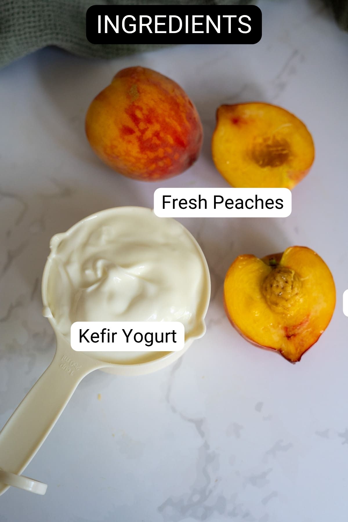 A measuring jug of kefir yoghurt next to three fresh peach halves on a white surface, labelled as "Kefir Yoghurt" and "Fresh Peaches.