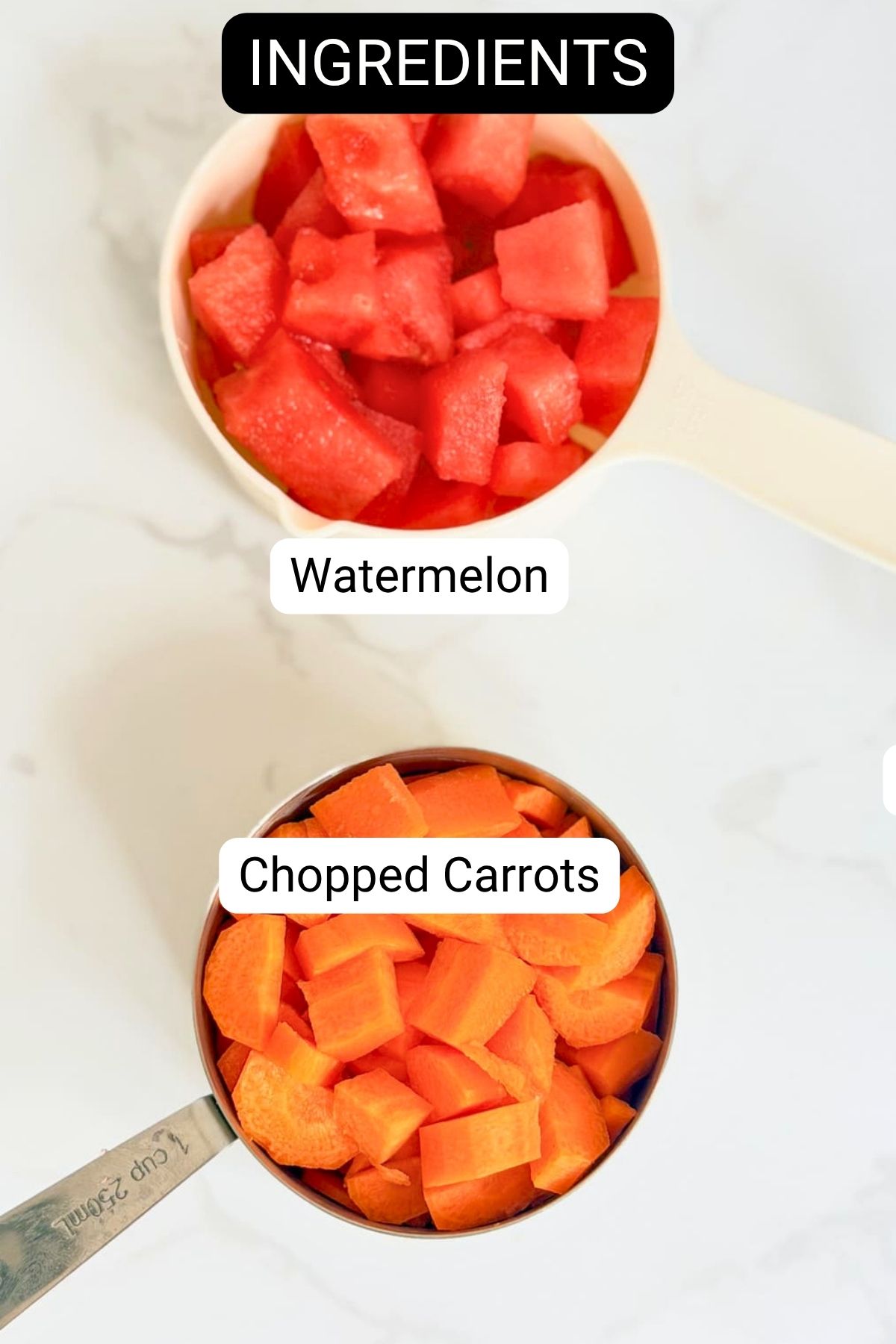 A measuring jug of diced watermelon and a measuring jug of chopped carrots on a white surface, labelled as ingredients.
