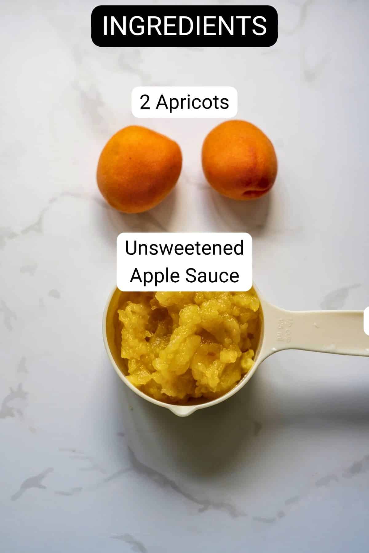 Two whole apricots and a measuring jug filled with unsweetened apple sauce placed on a white surface, labelled as ingredients.