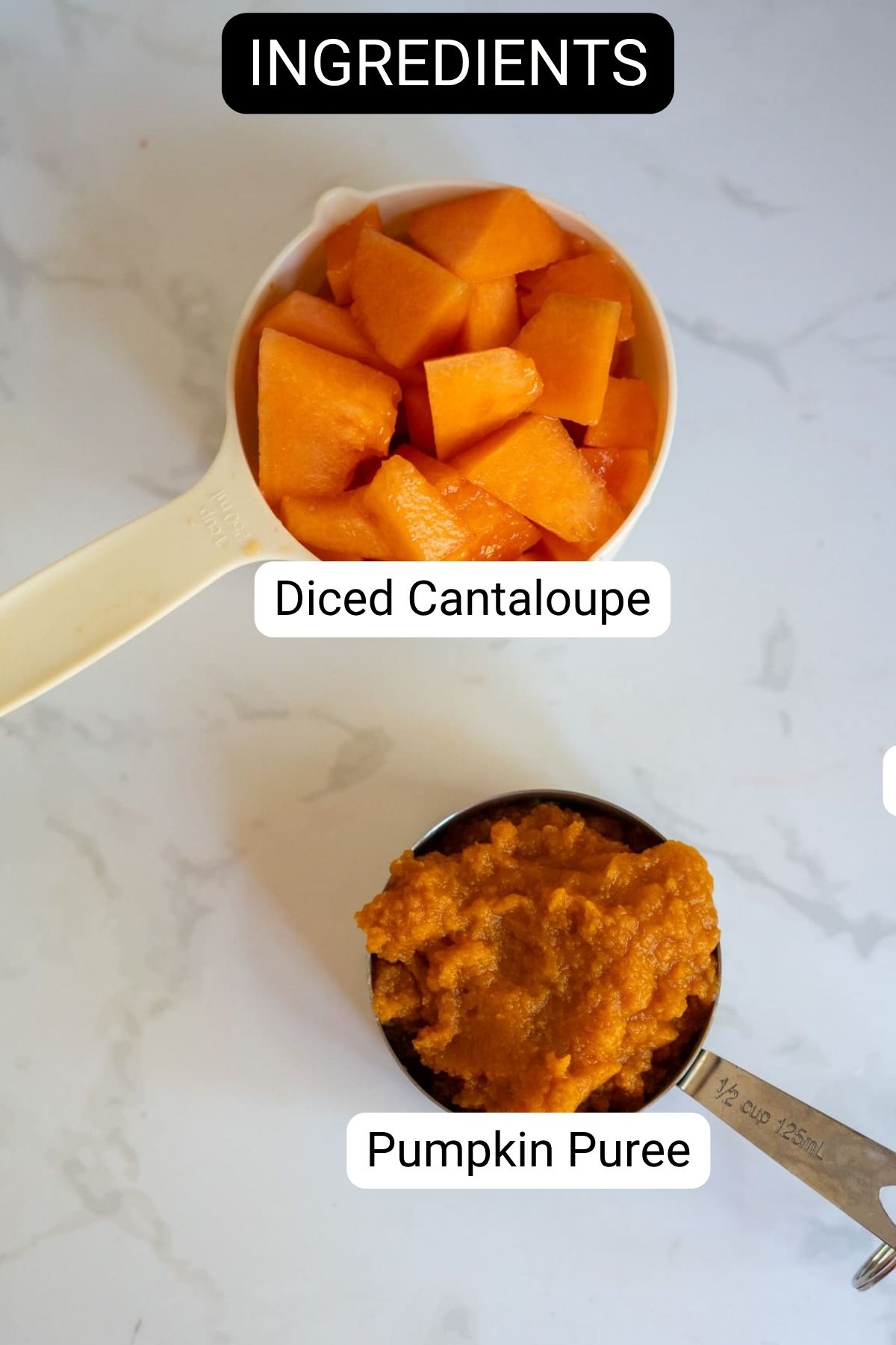 A measuring jug of diced cantaloupe and a measuring jug of pumpkin purée are labelled on a white marble surface, ready to be used for homemade Cantaloupe Pumpkin Frozen Dog Treats.