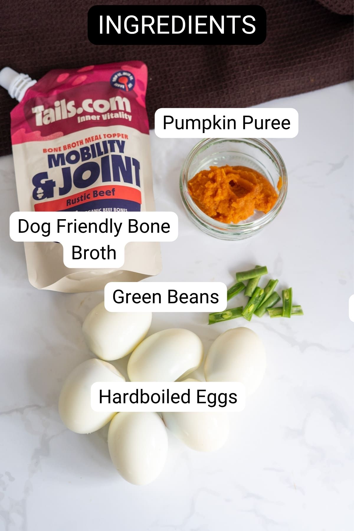 Ingredients for dog food: a sachet of Tails.com bone broth, a small bowl of pumpkin purée, chopped green beans, and four hard-boiled eggs to make pumpkin devilled eggs for dogs.